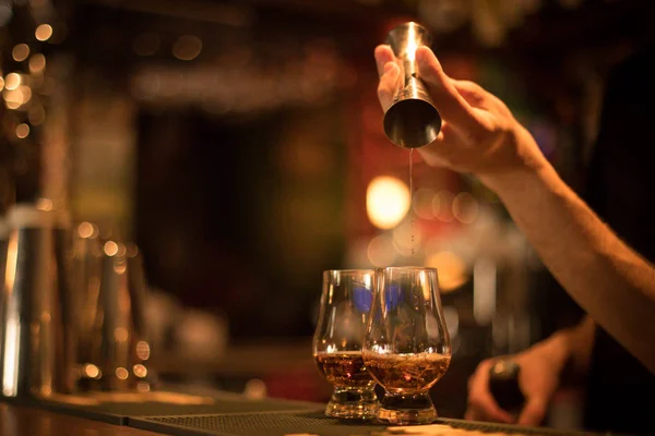 Barman derramando uísque em um copo — Fotografia de Stock