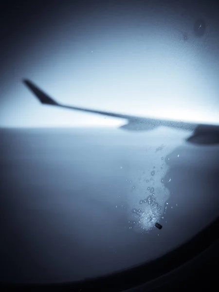 Un pequeño agujero en la ventana de un avión — Foto de Stock