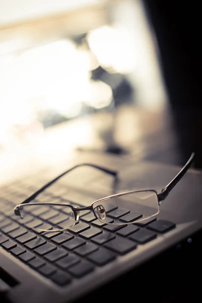 Par de gafas en un teclado portátil — Foto de Stock