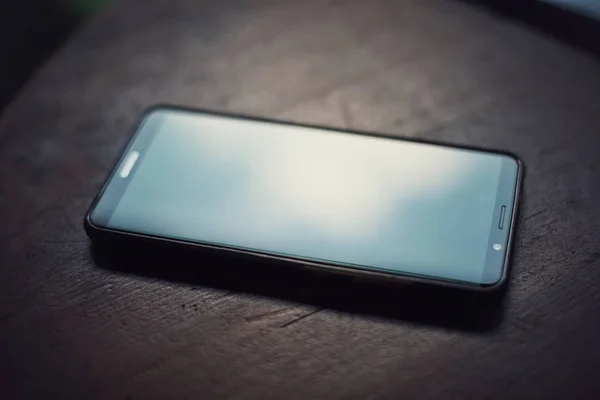 Smart phone på ett träbord — Stockfoto
