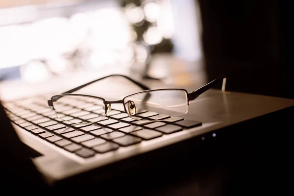 Coppia di occhiali su una tastiera di computer portatile — Foto Stock