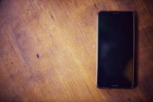 Smart phone on a wooden table — Stock Photo, Image