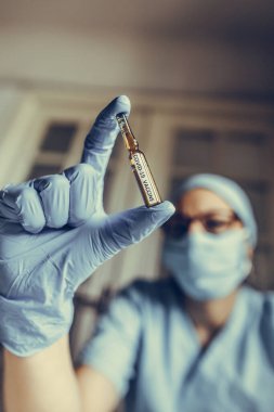 Coronavirus COVID-19 aşısı olan bir hastayı tutan bir hemşirenin kavramsal görüntüsü..