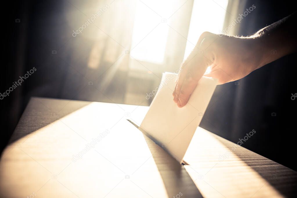 Conceptual image of a person voting, casting a ballot at a polling station, during elections.