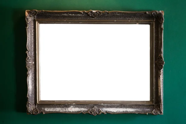 Image o a classic vintage painting frame, wit copy space, on a green wall.