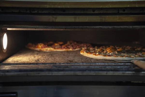 Pizzas in the Oven of the Pizza Shop