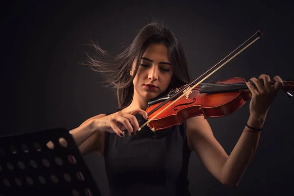 Bella giovane donna che suona un violino su sfondo nero — Foto Stock