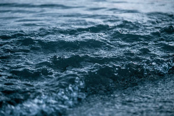 Foto de primer plano de hermosa superficie de agua de mar azul oscuro claro con olas olas bajas sobre el fondo del paisaje marino . —  Fotos de Stock