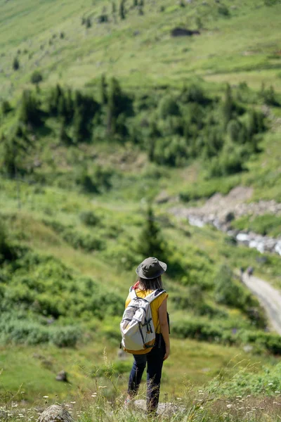 Mulher com mochila em pé na rocha e olhando para a vista . — Fotografia de Stock
