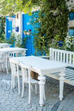 Güzel taş yol eski geleneksel evleri ve geleneksel beyaz kahve masa ve sandalyeler ile Yunanistan'da yapılan.