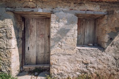 Eski ahşap pencere ve kapı eski bir taş duvar.