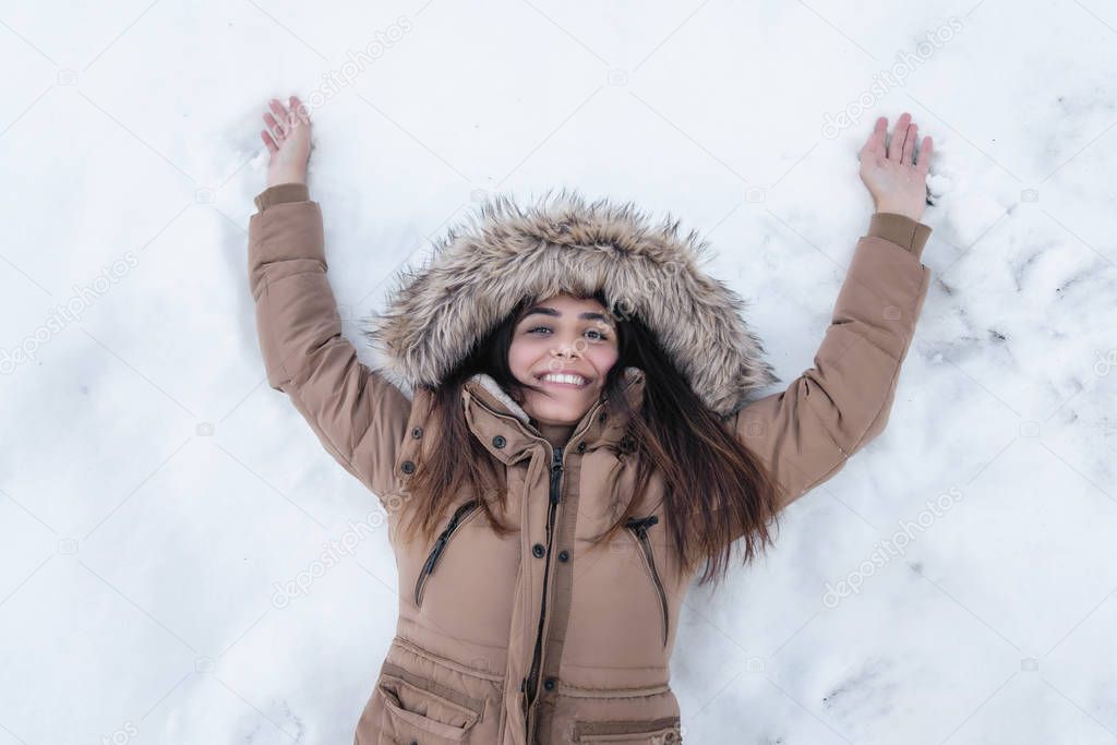 Attractive and cheerful young woman in wintertime outdoor.