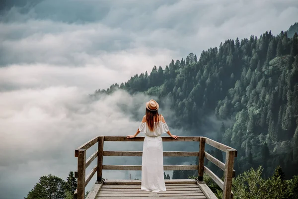 La femme avec chapeau et robe blanche debout contre les montagnes dans la nature — Photo