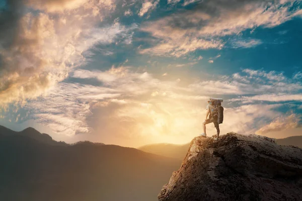 Wanderer mit Rucksack steht auf einem Berg und genießt. — Stockfoto