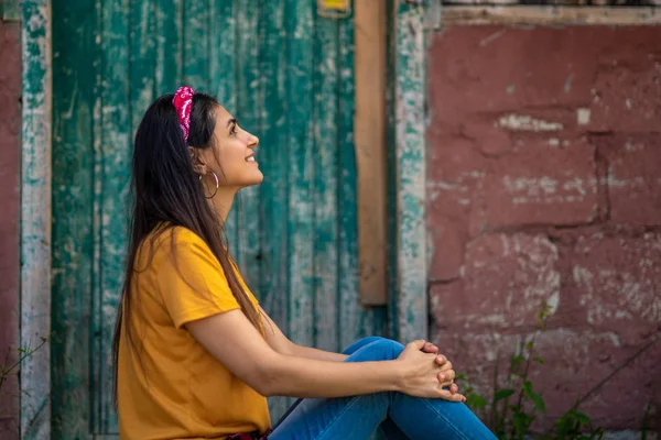 Une belle femme brune vêtue d'un jean élégant et d'un T-shirt jaune  . — Photo