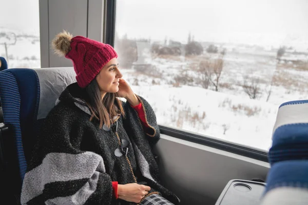 Jeune voyageuse assise dans le train, regardant par la grande fenêtre . — Photo