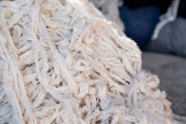 Sucatas de tecido, roupas antigas e têxteis são cortados em tiras à espera de reciclagem . — Fotografia de Stock