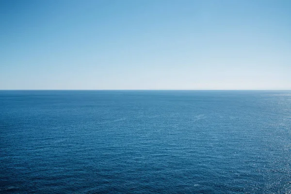 Cielo blu pulito sopra una superficie blu del mare . — Foto Stock