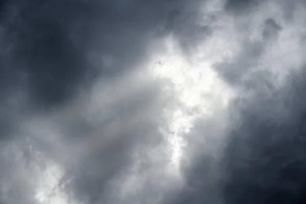 Драматический темный облачный фон неба с красивым солнечным лучом — стоковое фото