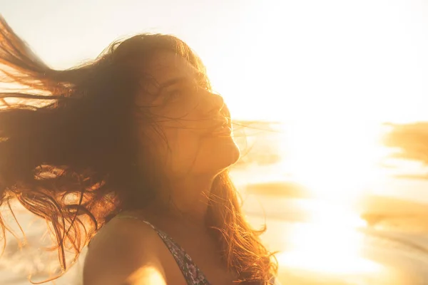 Liberdade mulher feliz e livre braços abertos na praia ao pôr do sol ensolarado . — Fotografia de Stock