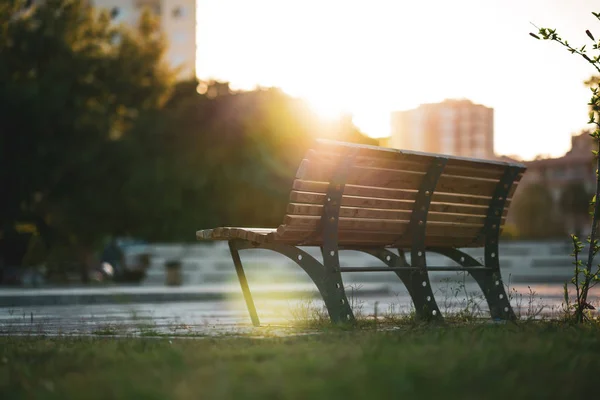 Bench on sunset with sunbeam on the street.City landscape. — Stock Photo, Image