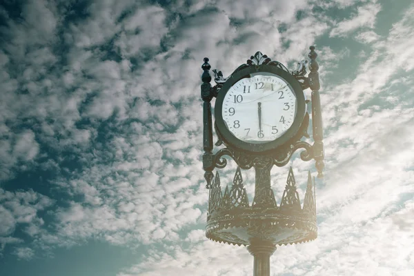 Vintage analogue clock against sunset with beautiful clouds. — Stock Photo, Image