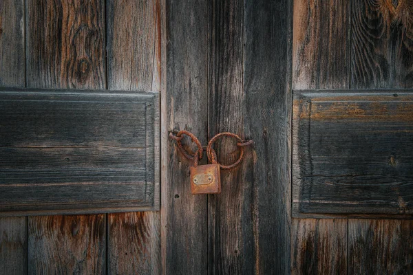Starý rezavý zámek na hnědých dřevěných dveřích — Stock fotografie