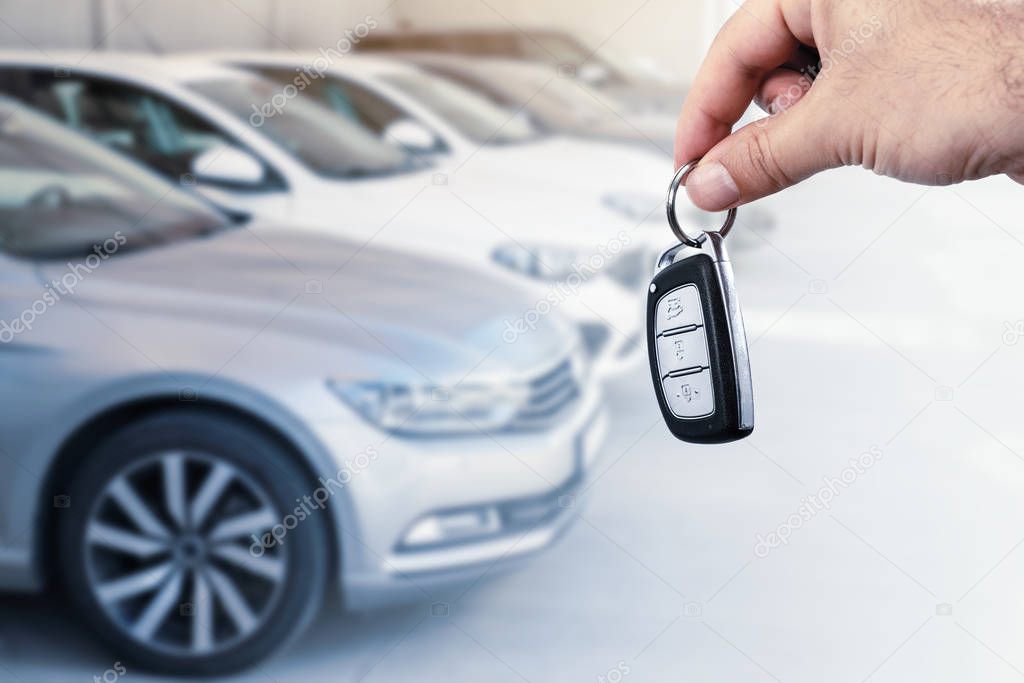 Mans hand holding car key.Automobile rent or leasing concept.