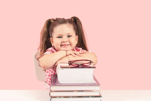 Sonriente rubia pequeña linda chica estudiando en libros —  Fotos de Stock