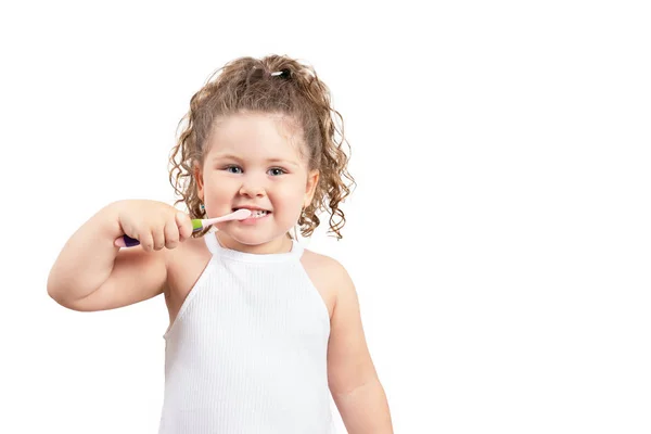 Linda chica rubia cepillándose los dientes sobre un fondo blanco aislado . —  Fotos de Stock