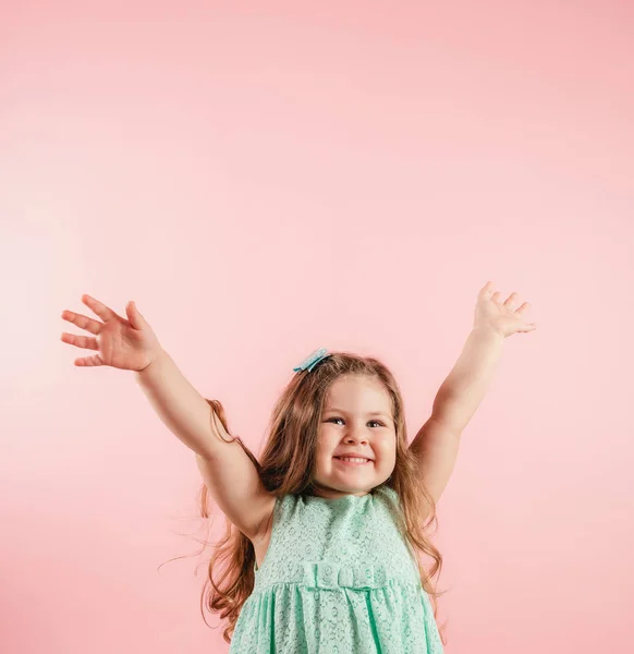 Alegre niña abrir las manos contra el fondo rosa . —  Fotos de Stock