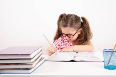 sarışın küçük sevimli kız beyaz arka plan üzerinde kitaplar üzerinde eğitim.