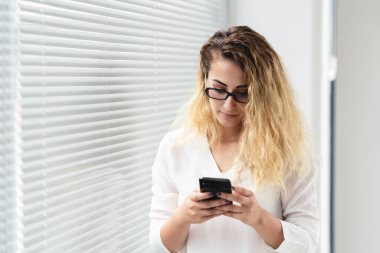 Genç kadın telefonuyla mesaja cevap veriyor