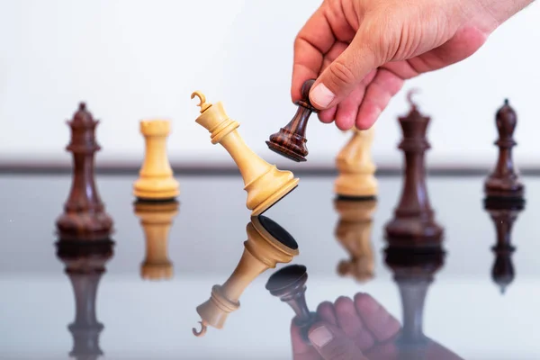 Businessman  in the chess game king is checkmated by pawn