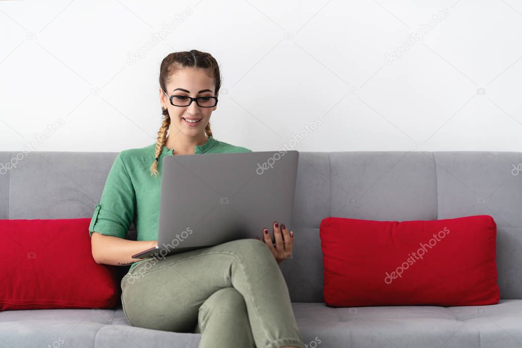 smiley young woman working on laptop at home