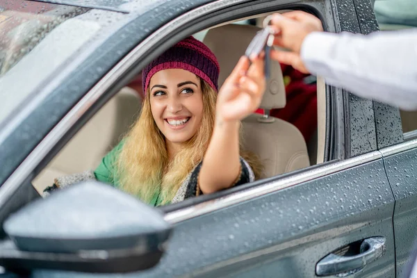 Giovane donna prendere la chiave dal parcheggiatore per guidare la sua auto — Foto Stock