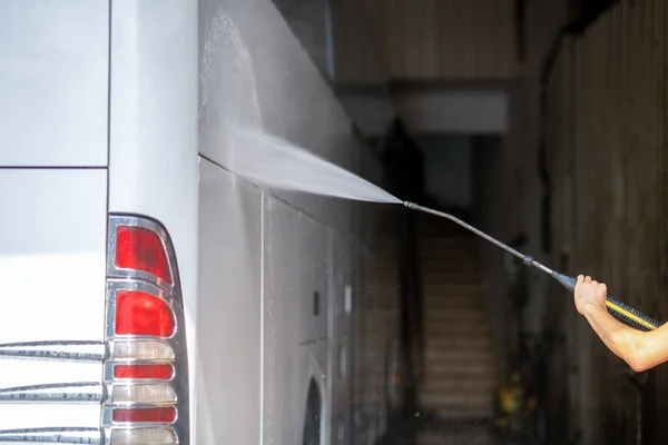 Buss får tvättas från en bricka med vattenstråle i garage — Stockfoto