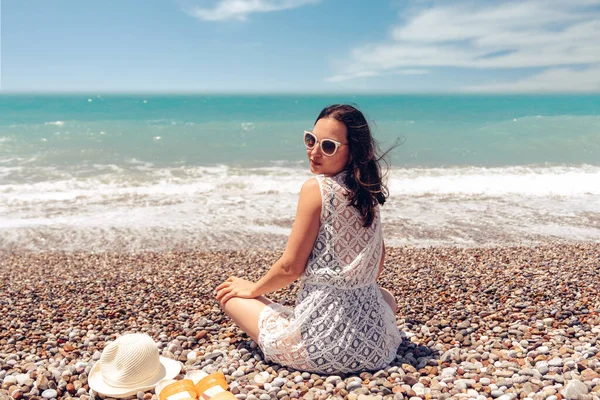 Красивая сидящая женщина наслаждается идиллической сценой солнца, моря и пляжа. Прекрасный пляж в Анталии . — стоковое фото