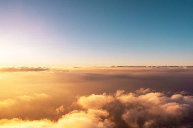 Güneşin doğuşunun ya da batışının panoramik üst görüntüsü ve mavi gökyüzünün, gökyüzünün ve bulutların altındaki tüm bulutlar üzerinde pankart, duvar kağıdı konsepti.