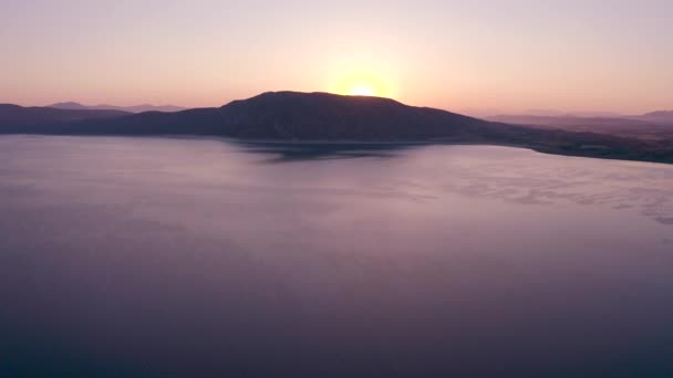 4K βίντεο εναέρια άποψη της λίμνης Salda στην Τουρκία με την ανατολή και τη σιλουέτα λόφο φόντο. Ταξιδιωτικός τουρισμός έννοια. — Αρχείο Βίντεο