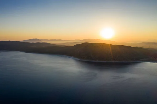 Una vista aerea di un lago con alba e sfondo collina silhouette. Turismo di viaggio concetto. — Foto Stock