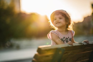 Parkta bankta duran güzel ve mutlu bir kızın portresi.