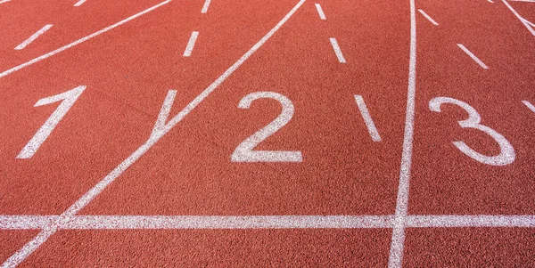 Weiß bemalte Linien und Zahlen auf einer Laufbahn auf einem Sportplatz. — Stockfoto