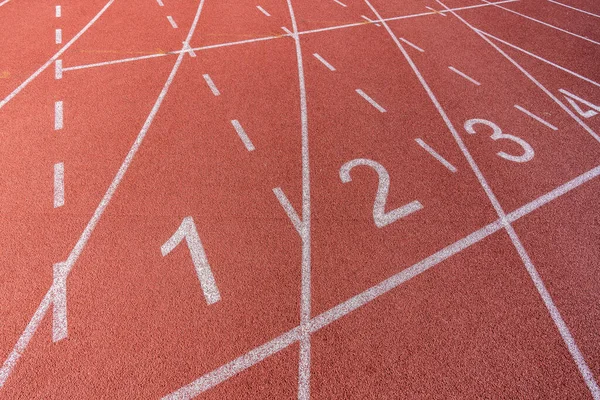 Atletizm ve spor sahasında koşan bir pistte beyaz çizgiler ve numaralar. — Stok fotoğraf