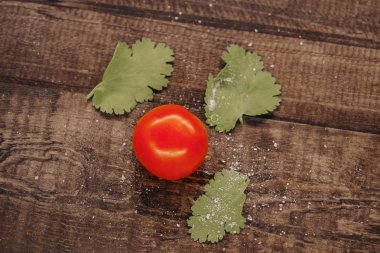 lezzetli kiraz domates ahşap bir arka plan üzerinde tuz serpilir
