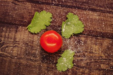 lezzetli kiraz domates ahşap bir arka plan üzerinde tuz serpilir