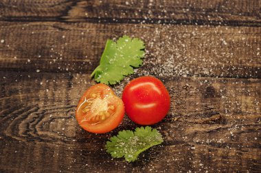 lezzetli kiraz domates ahşap bir arka plan üzerinde tuz serpilir