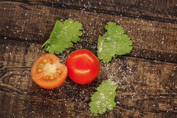 lezzetli kiraz domates ahşap bir arka plan üzerinde tuz serpilir