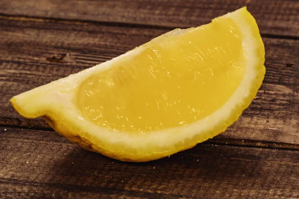 Limão amarelo e fresco. fatias de limão no fundo de madeira — Fotografia de Stock