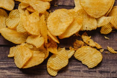 ahşap arka plan üzerinde gevrek patates cipsi. cips başladı